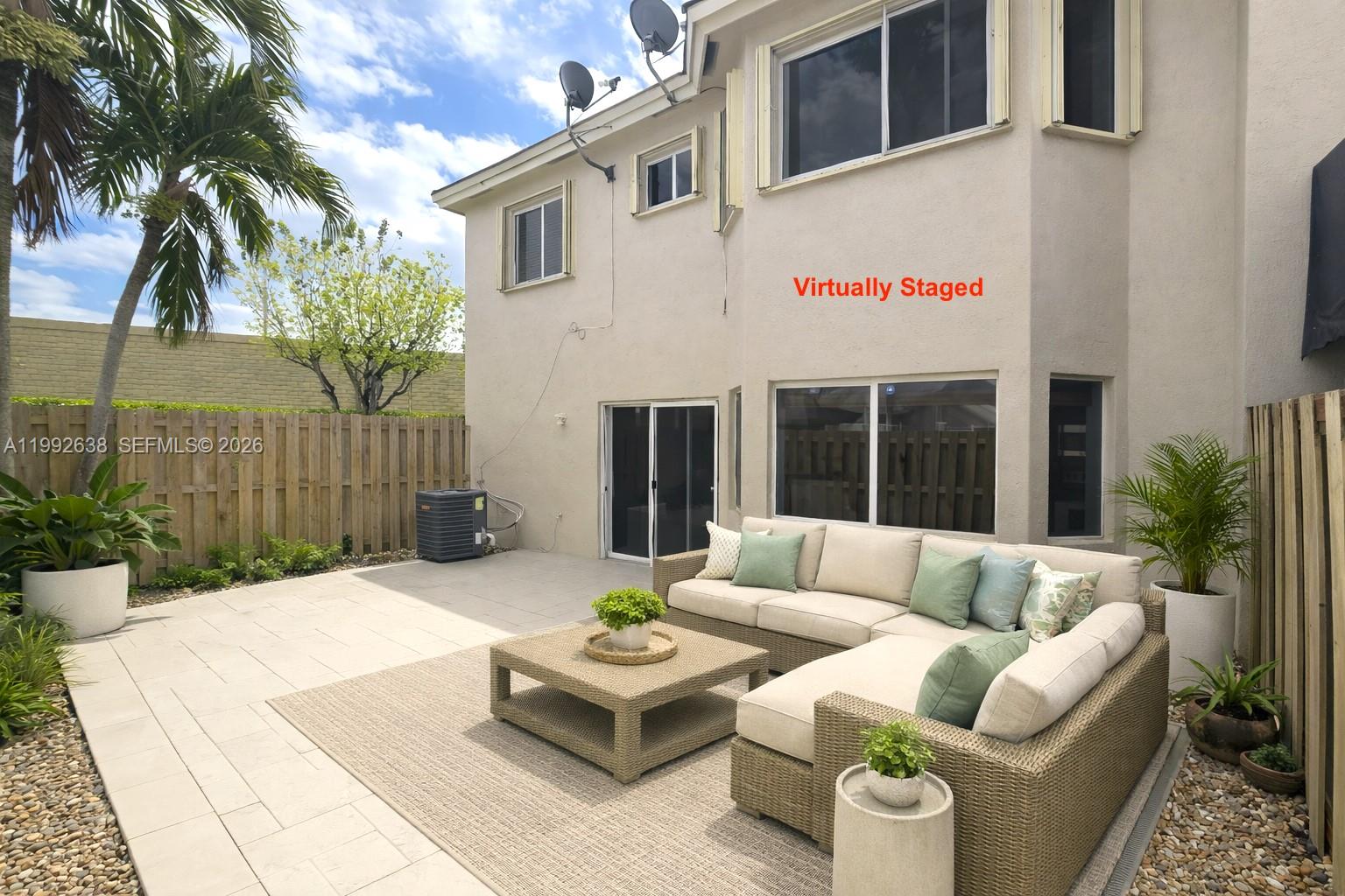 8421 Southwest 124th Avenue, Unit 101 Miami, FL 33183 - Photo 18 of 20 a view of a patio with couches table and chairs and potted plants