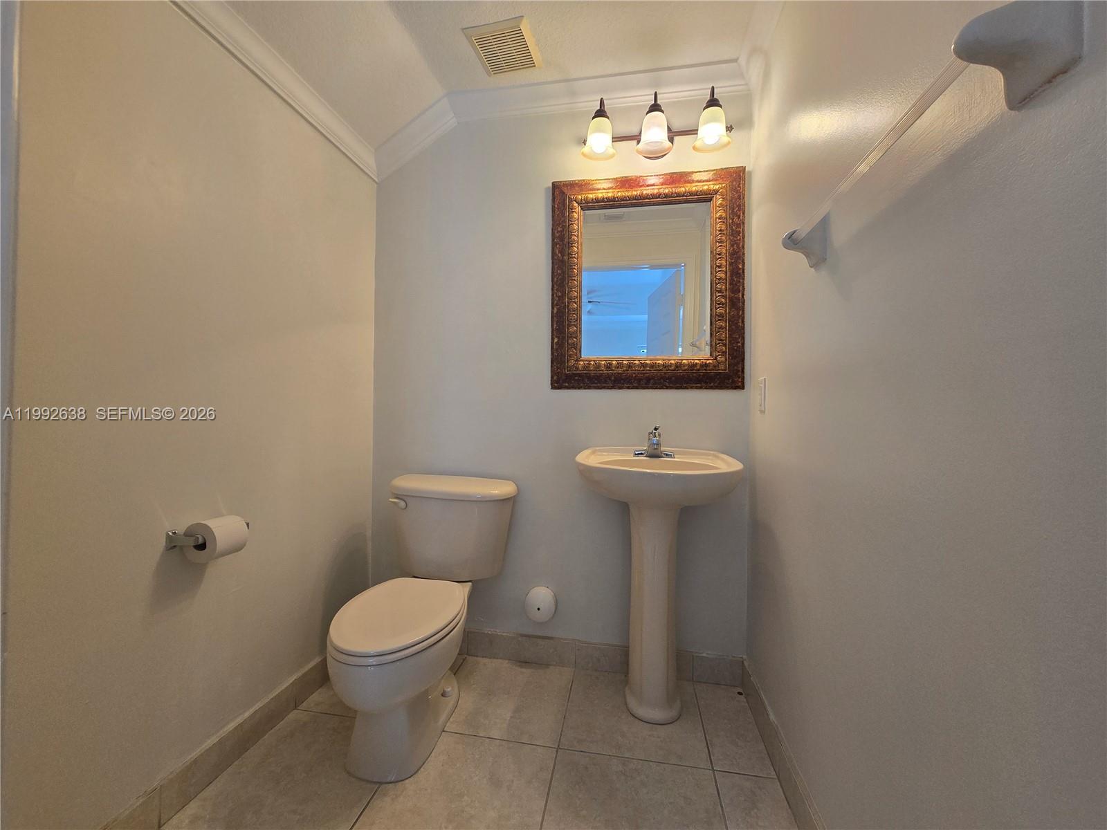 8421 Southwest 124th Avenue, Unit 101 Miami, FL 33183 - Photo 10 of 20 a bathroom with a toilet sink and mirror