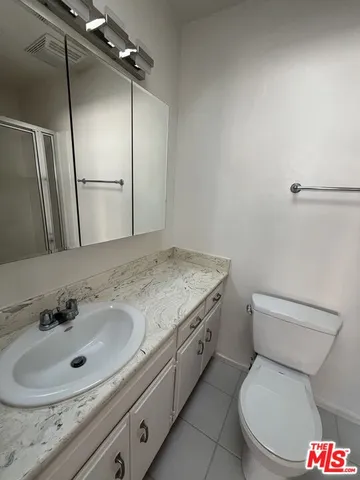 a bathroom with a sink a toilet a mirror and shower