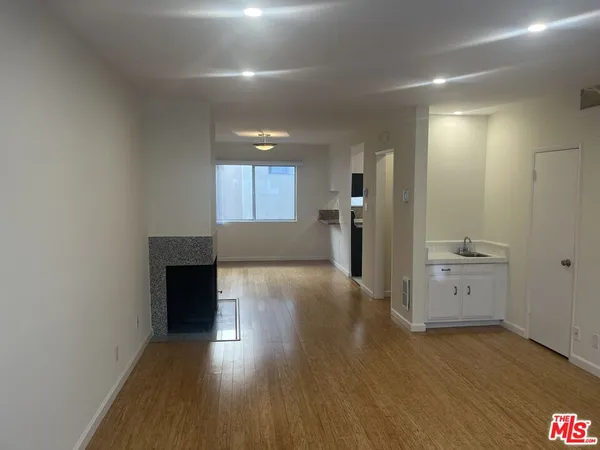 an empty room with wooden floor and a window