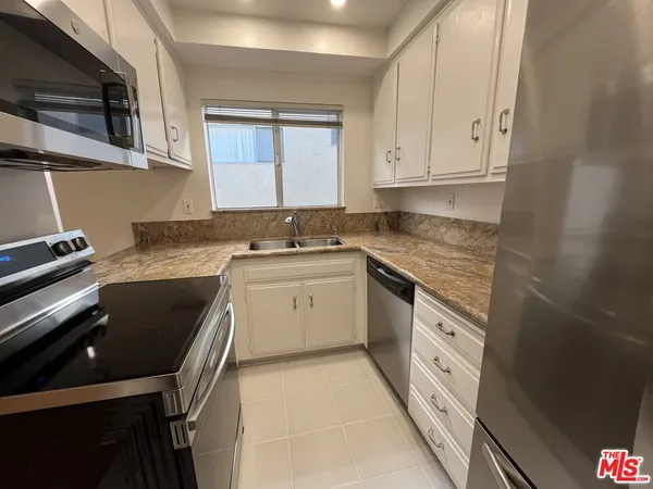 a kitchen that has a sink and a stove in it