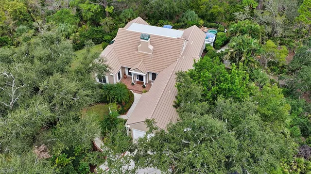 an aerial view of a house with a yard and large trees