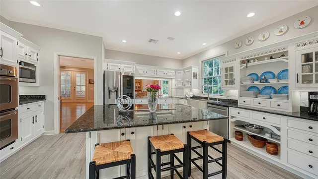 a spacious bedroom with a bed a dresser and a chandelier