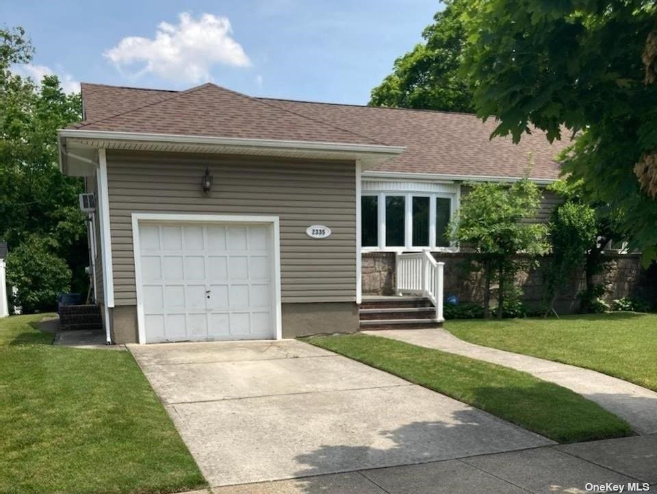 2335 Charing Cross Road Baldwin, NY 11510 - Photo 1 of 1 a front view of a house with a garden and yard