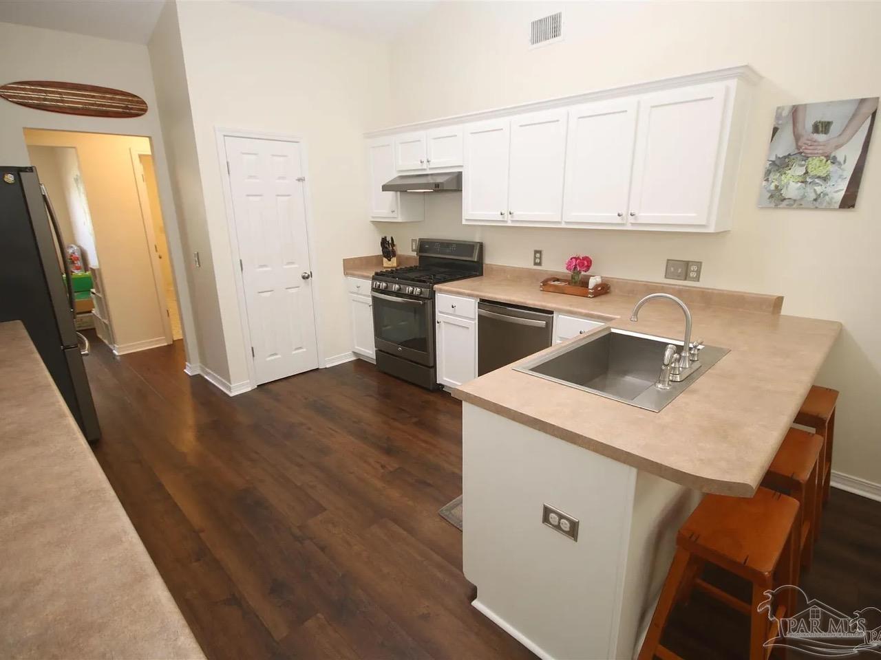 4930 Chads Circle Pace, FL 32571 - Photo 4 of 18 a kitchen with a sink a stove a refrigerator and a window