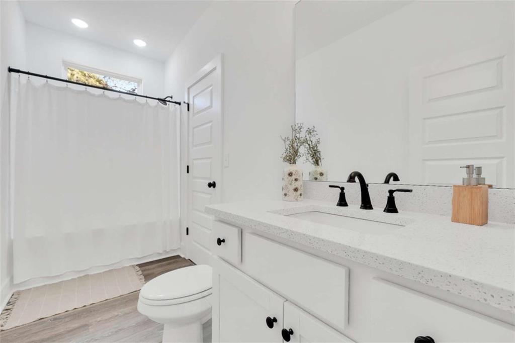 65 Lakeside Drive Covington, GA 30016 - Photo 22 of 35 a bathroom with a granite countertop sink a toilet and a mirror