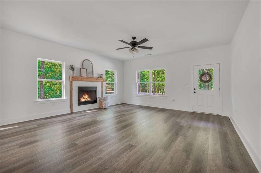 65 Lakeside Drive Covington, GA 30016 - Photo 9 of 35 an empty room with windows a fireplace and wooden floor