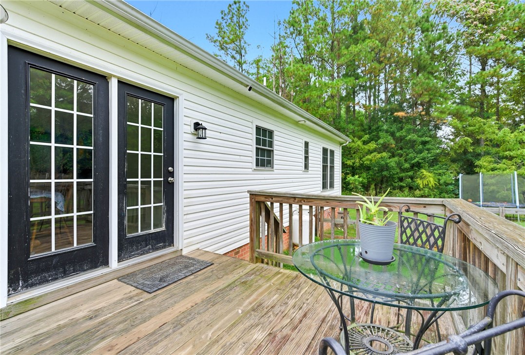 878 Salvia Road Newtown, VA 23126 - Photo 22 of 33 Wooden terrace with a trampoline and view of wooded area