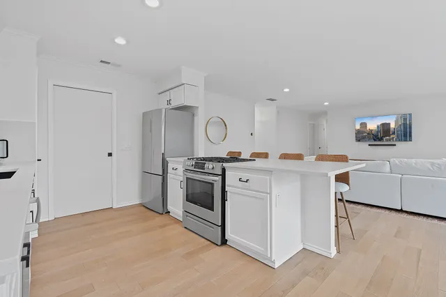 a kitchen with white cabinets and stainless steel appliances