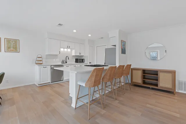 a living room with kitchen island furniture and wooden floor
