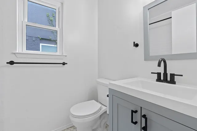a bathroom with a sink toilet and a mirror