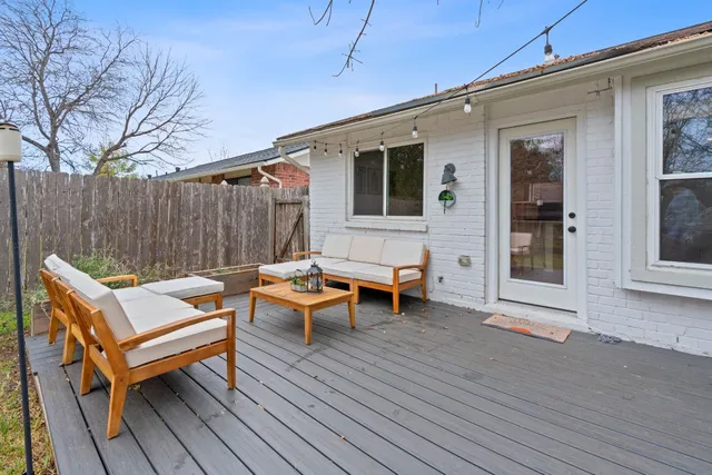 a backyard of a house with wooden floor outdoor seating and yard in the back