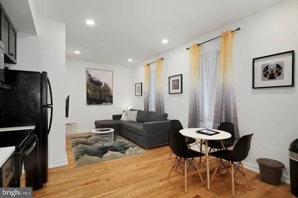 a living room with furniture a wooden floor and a flat screen tv