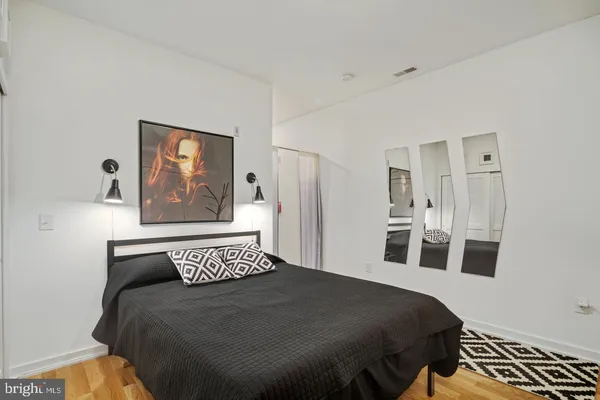 a bedroom with a large bed and paintings on the wall