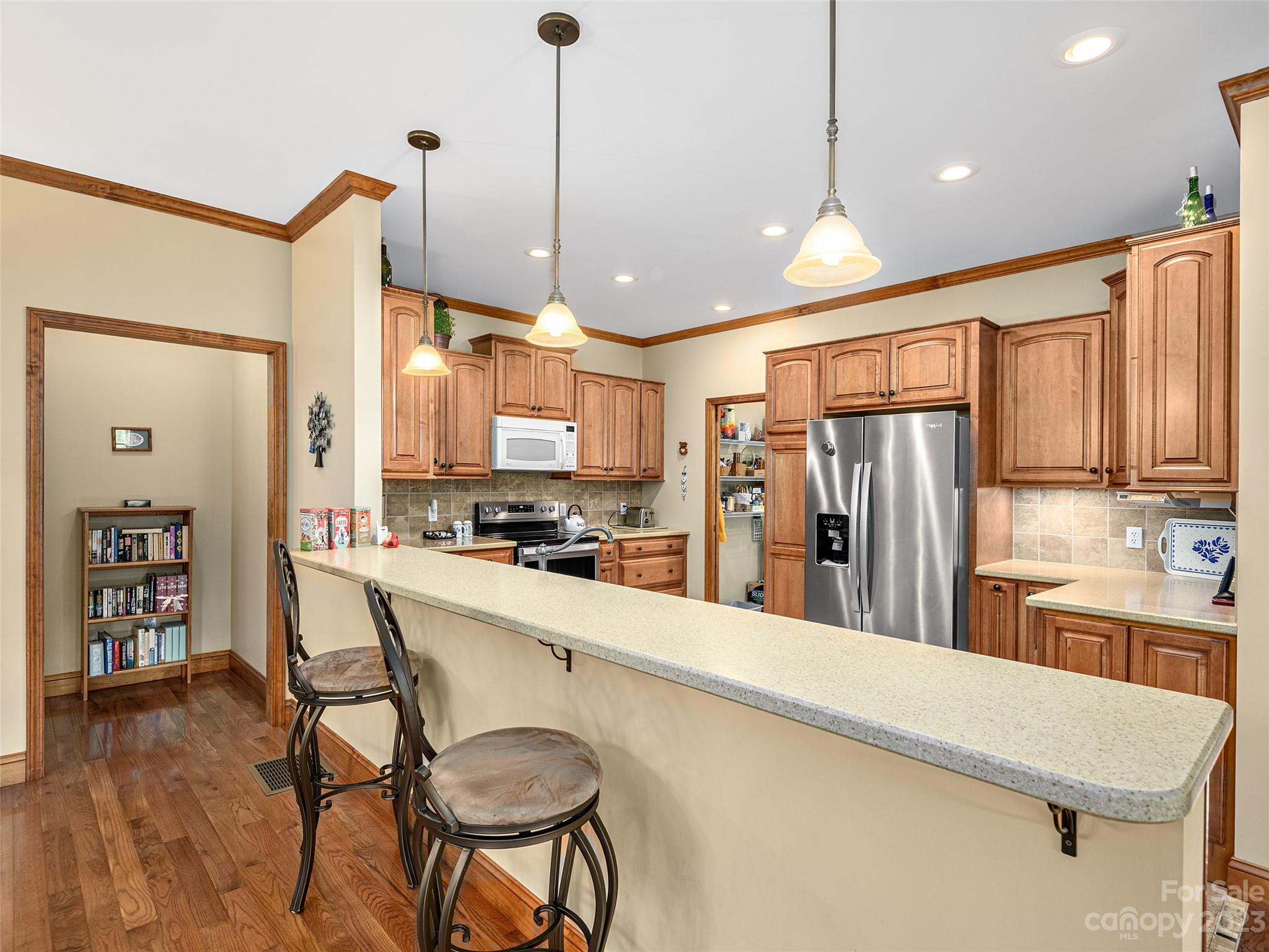 1223 North Ridge Road Hendersonville, NC 28792 - Photo 9 of 24 a kitchen with stainless steel appliances a refrigerator sink and wooden cabinets