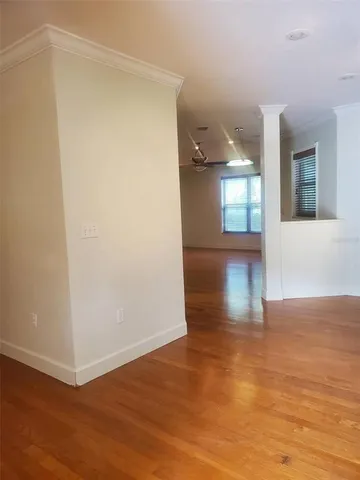 a view of empty room with wooden floor