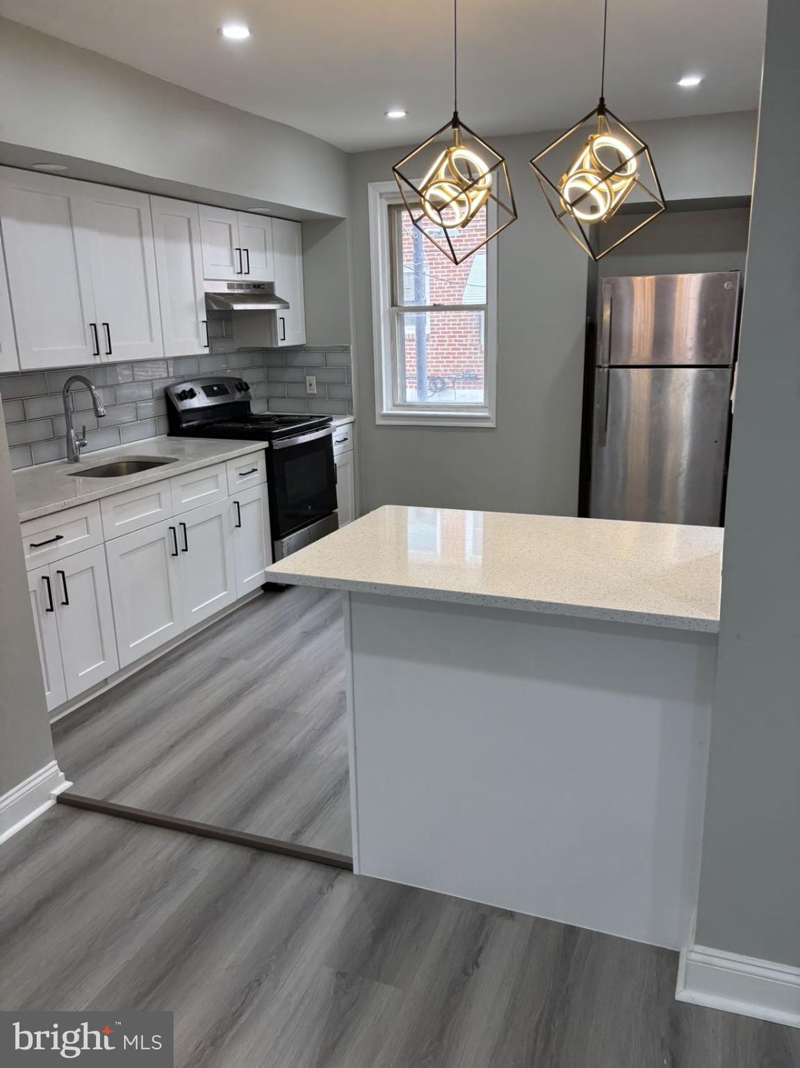 a kitchen with kitchen island granite countertop stainless steel appliances a stove refrigerator and microwave