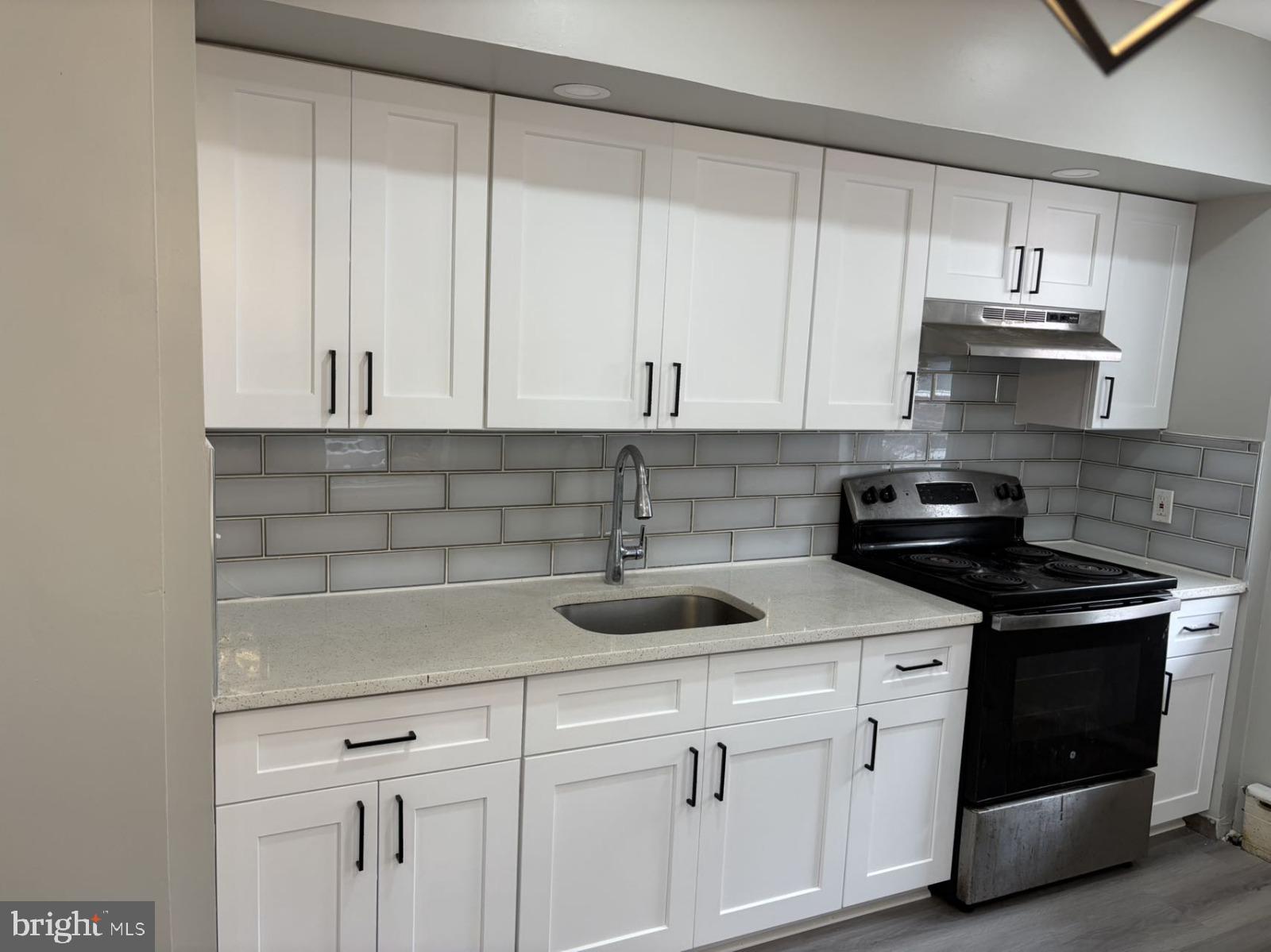 4007 Higbee Street Philadelphia, PA 19135 - Photo 18 of 20 a kitchen with stainless steel appliances granite countertop white cabinets a sink and dishwasher