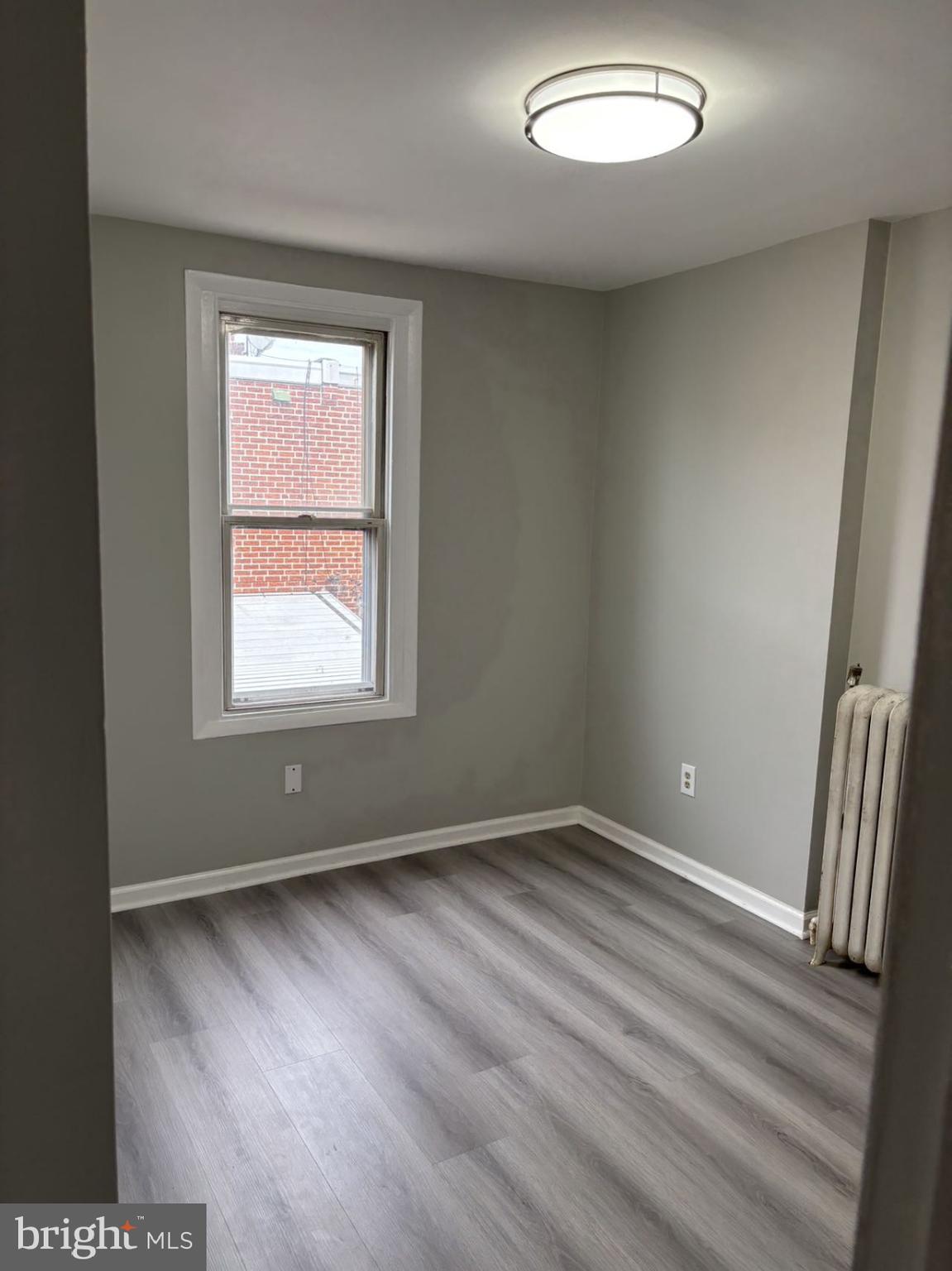 4007 Higbee Street Philadelphia, PA 19135 - Photo 4 of 20 an empty room with wooden floor and windows