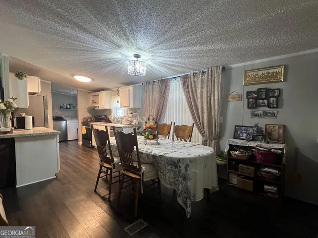 a view of a dining room with furniture and a chandelier
