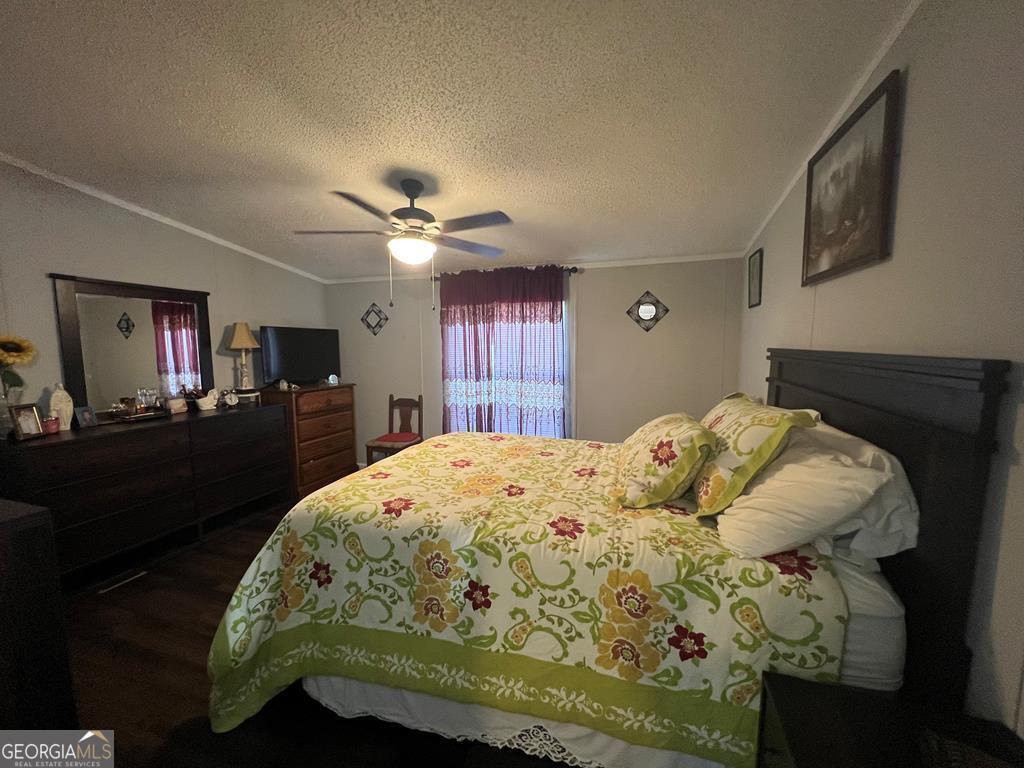 166 Pebble Hills Road Cochran, GA 31014 - Photo 15 of 22 a bedroom with a bed and a chandelier