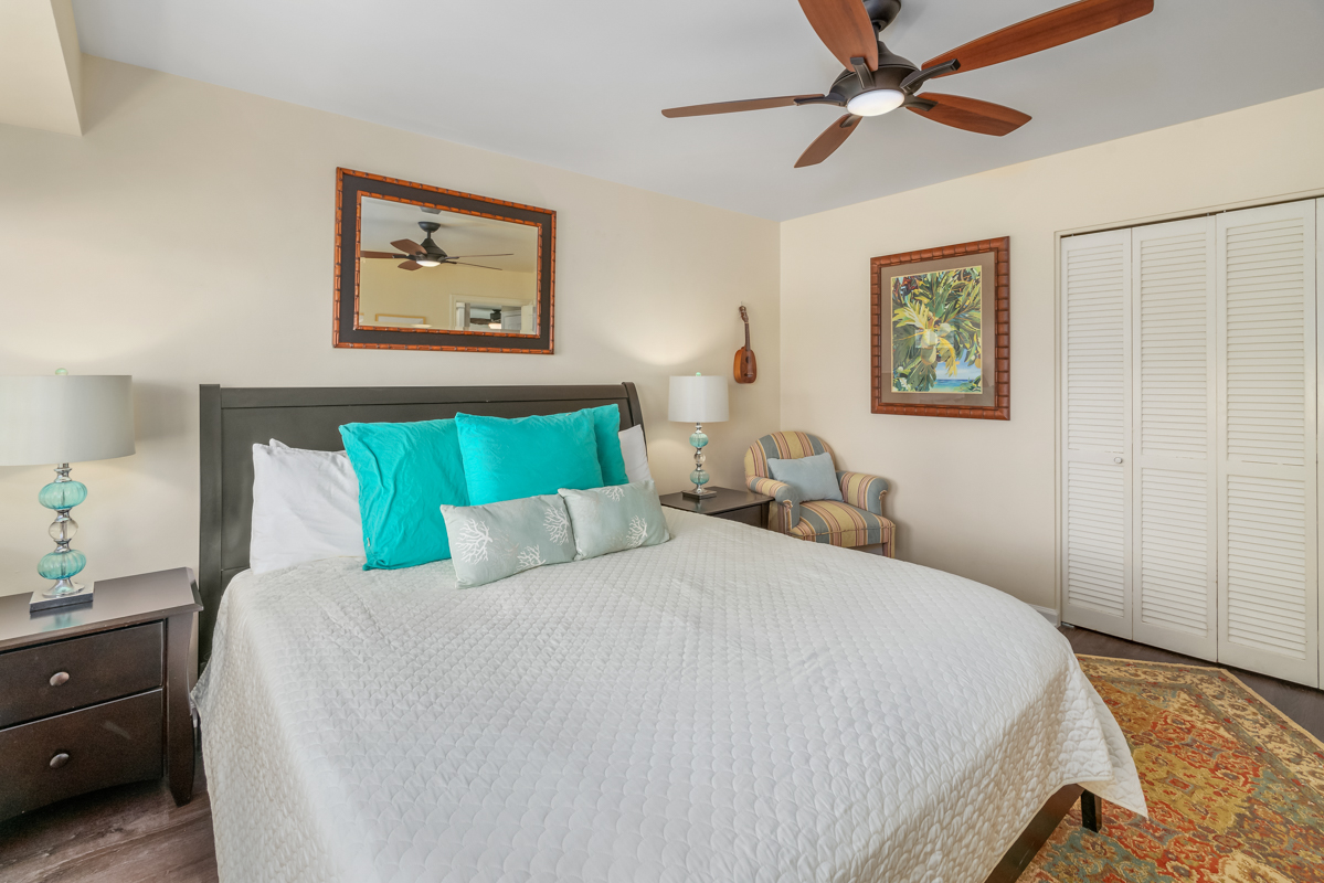 3830 Edward Road, Unit 9F Princeville, HI 96722 - Photo 19 of 20 a bedroom with a bed and a chandelier