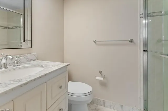 a bathroom with a granite countertop sink toilet and shower