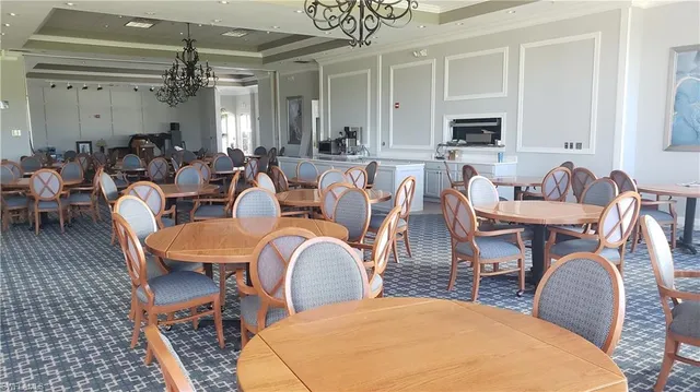 a dining room with furniture a chandelier and window