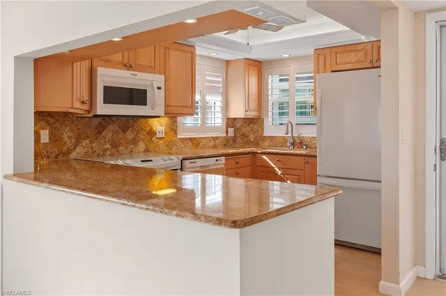 a kitchen with stainless steel appliances granite countertop a sink and a microwave