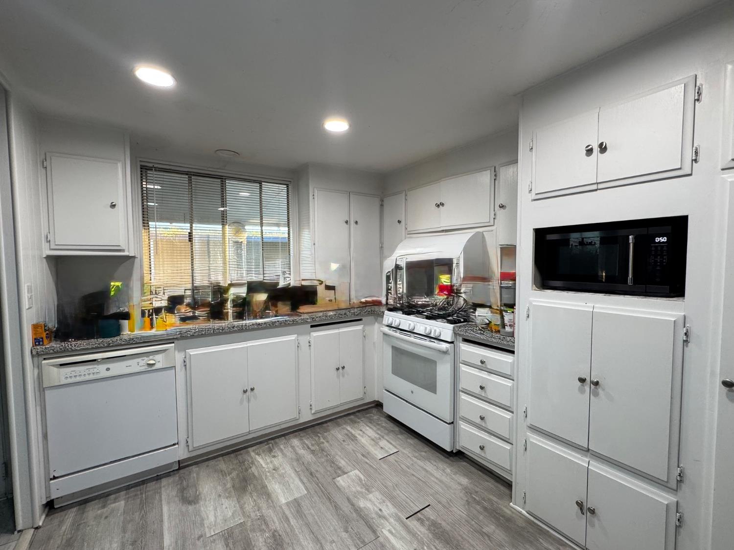 10035 Mills Station Road, Unit 161 Sacramento, CA 95827 - Photo 6 of 15 a kitchen with white cabinets and white appliances