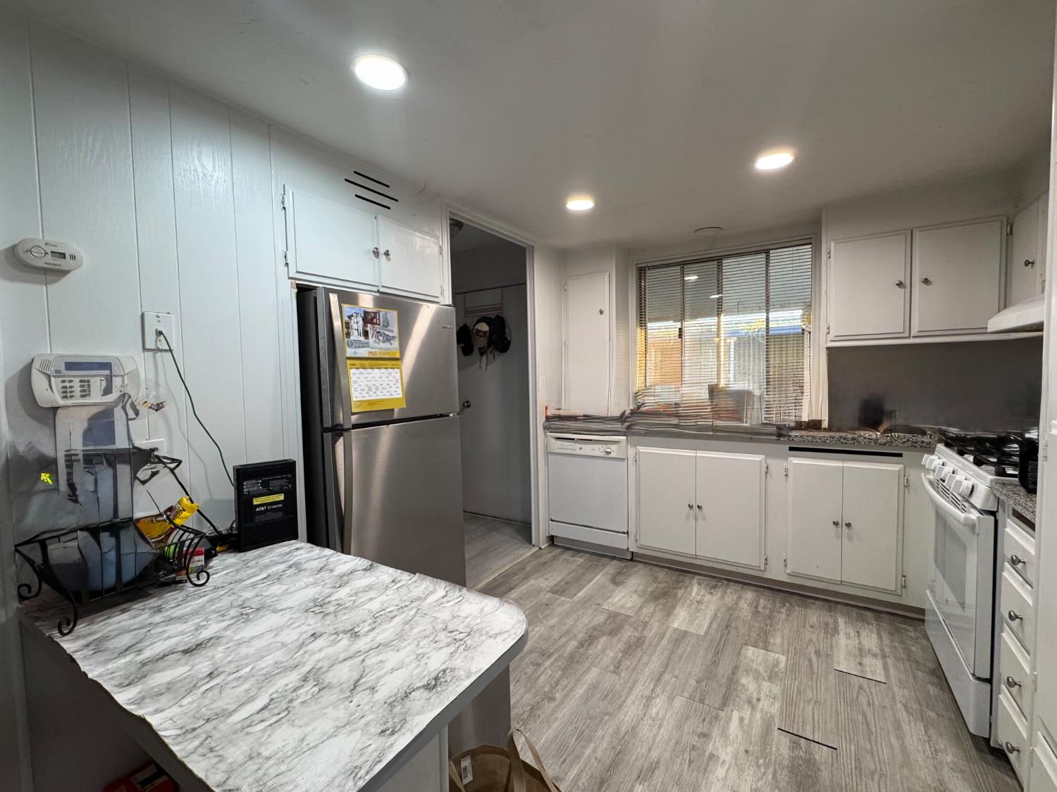 10035 Mills Station Road, Unit 161 Sacramento, CA 95827 - Photo 7 of 15 a kitchen with refrigerator cabinets and wooden floor