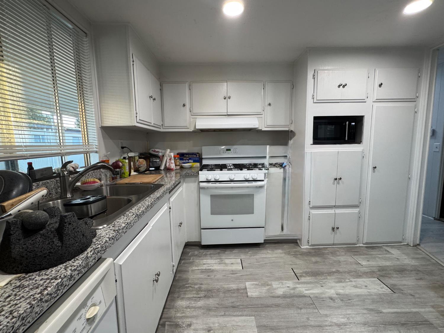 10035 Mills Station Road, Unit 161 Sacramento, CA 95827 - Photo 8 of 15 a kitchen with white cabinets and appliances
