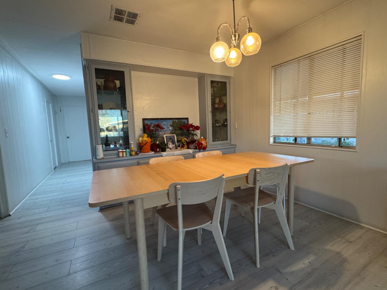 10035 Mills Station Road, Unit 161 Sacramento, CA 95827 - Photo 9 of 15 a dining room with wooden floor a chandelier a wooden table and chairs