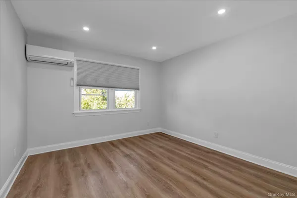 a view of empty room with window and ceiling fan