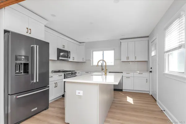 a kitchen with stainless steel appliances granite countertop a refrigerator sink and stove