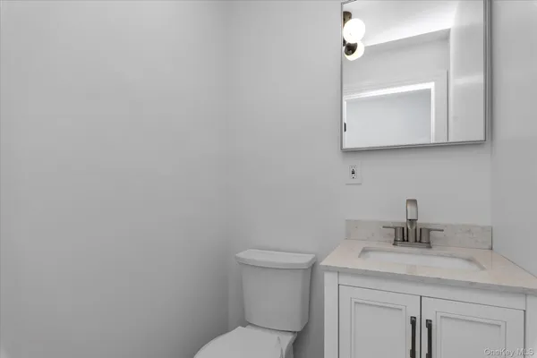a bathroom with a granite countertop toilet sink and mirror