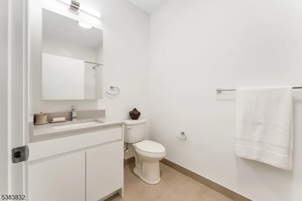 a bathroom with a granite countertop sink a toilet and a mirror