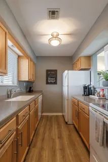 a kitchen with a sink stainless steel appliances cabinets and a window