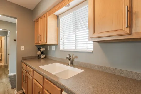 a kitchen with a sink cabinets and a window