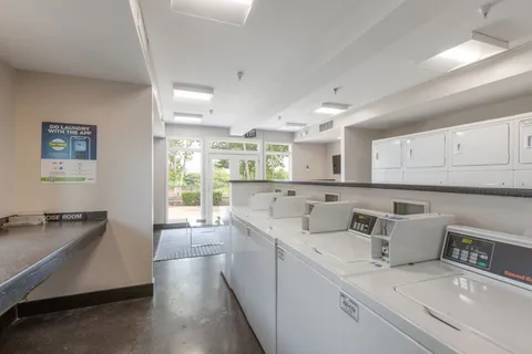 a living room with furniture a flat screen tv and kitchen view