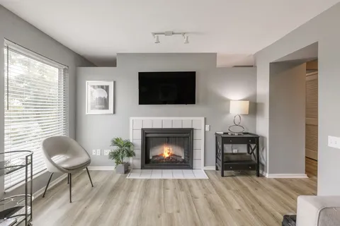 a living room with furniture a fireplace and a flat screen tv