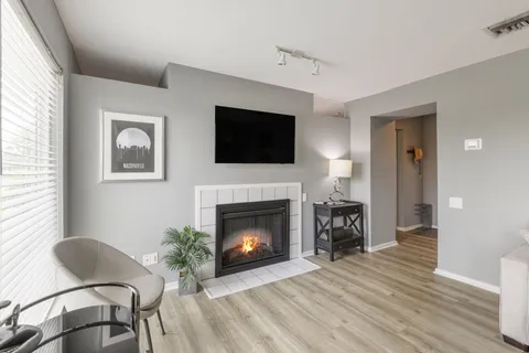 a living room with furniture a flat screen tv and a fireplace