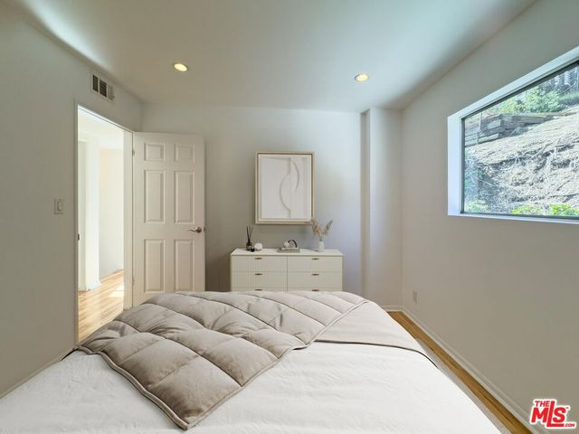 a bedroom with a bed and wooden floor