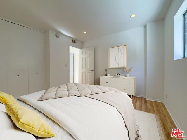 a bedroom with a bed and a painting on the wall