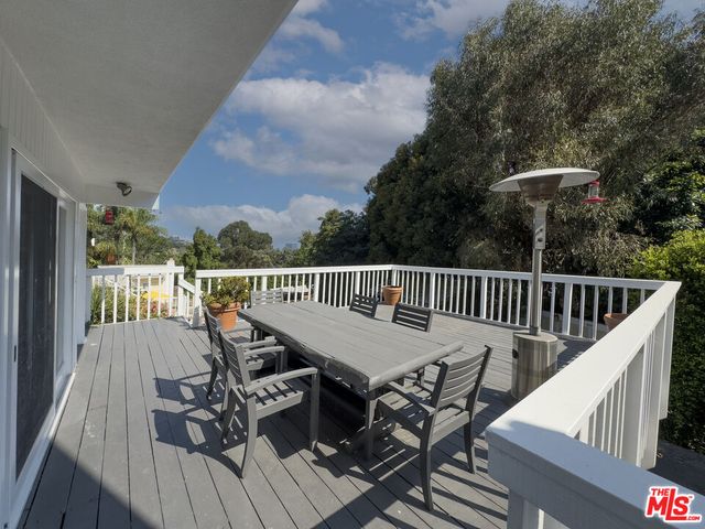 a view of a roof deck with table and chairs and wooden floor