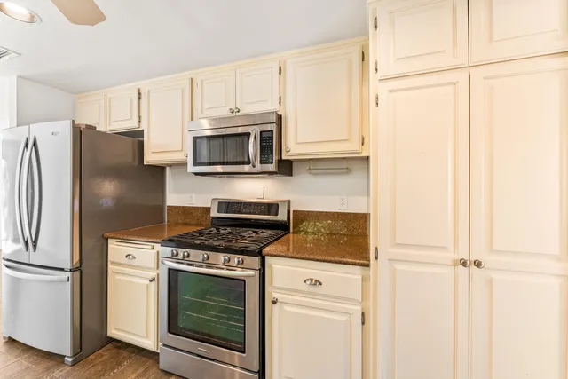 a kitchen with stainless steel appliances white cabinets and a stove top oven