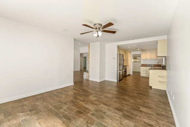 a view of a kitchen with wooden floor and a ceiling fan