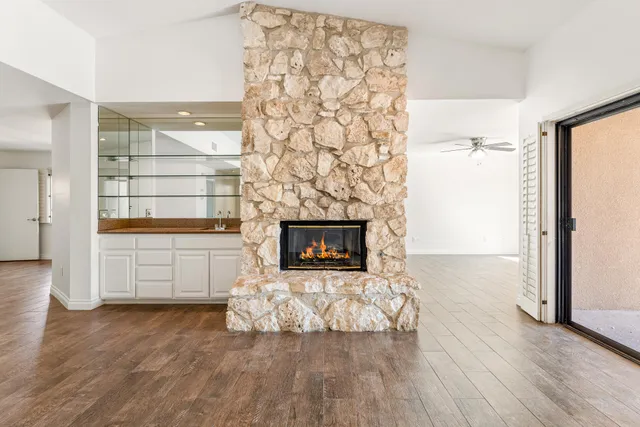 a view of empty room with a fireplace and wooden floor