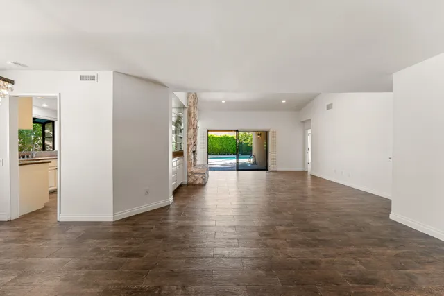 a view of a livingroom with wooden floor and a refrigerator