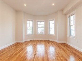 210 Adams Street, Unit 4 Waltham, MA 02453 - Photo 12 of 25 an empty room with wooden floor and windows